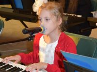 dziewczynka śpiewająca i grająca na keyboardzie