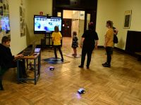 Dzieci i rodzice grają w grę interaktywną, wyświetlaną na ekranie