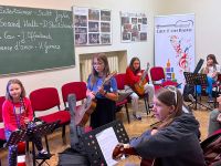 grupa dzieci za zajęciach gitarowych