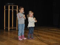 małe dzieci z mikrofonami na scenie