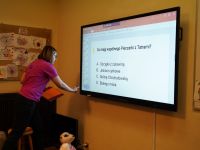 Dzieci wykonujące zadanie  podczas gry terenowej