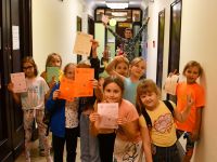 Grupa dzieci prezentuje karty startowe gry „Pałac Talentów”