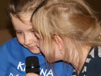 dwie małe dziewczynki śpiewające do mikrofonu